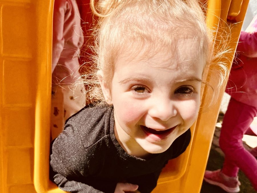 Menina sorrindo na casinha do parquinho